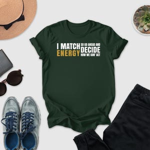 a green t-shirt with a humorous text, a pair of sunglasses, a hat, a wallet, a pair of sneakers, and a potted plant.