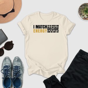 a casual outfit consisting of a white t-shirt with text, sunglasses, a hat, a wallet, a pair of shoes, and a potted plant.