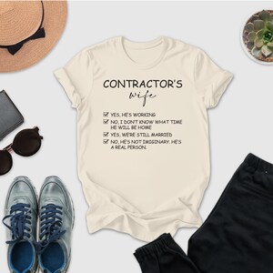 a casual outfit laid out on a white background, including a t-shirt with a humorous text, sunglasses, a hat, a wallet, a potted plant, and a pair of pants.