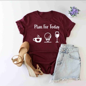Peut inclure: Un t-shirt bordeaux avec le texte "Plan for Today" et des ic&ocirc;nes blanches d'une tasse de caf&eacute;, d'une balle de golf et d'un verre &agrave; vin.