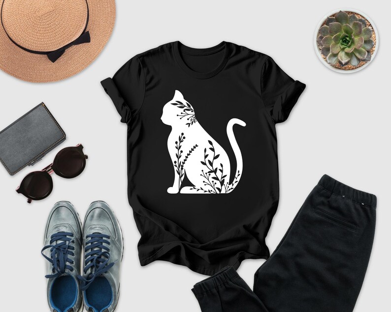 a casual outfit consisting of a black t-shirt with a white cat silhouette, a pair of gray sneakers, a pair of black pants, sunglasses, a hat, and a potted succulent plant.
