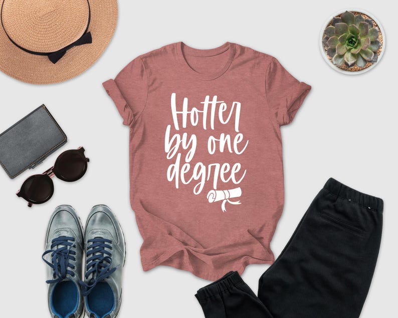 a casual outfit consisting of a pink t-shirt with a white text design, a pair of sunglasses, a hat, a wallet, a potted succulent plant, and a pair of sneakers.
