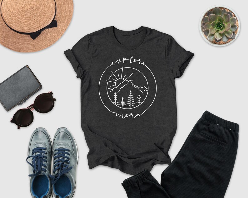 a casual outfit consisting of a black t-shirt with a graphic design, a pair of sunglasses, a hat, a wallet, a pair of shoes, and a potted succulent plant.