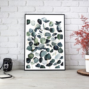May include: A framed print of a watercolor painting featuring a cluster of eucalyptus leaves in shades of green and blue against a white background.
