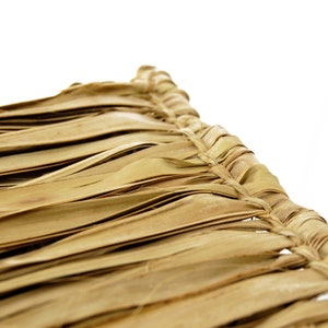 May include: Close-up of a woven thatched roof made of natural brown palm leaves. The leaves are woven together in a tight pattern, creating a durable and weather-resistant surface.