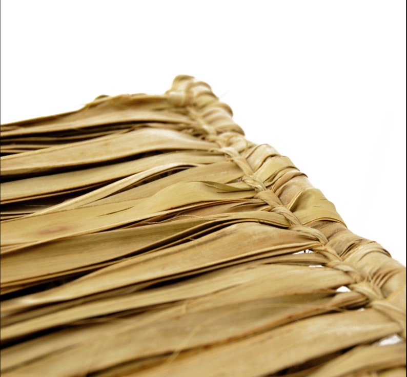 May include: Close-up of a woven thatched roof made of natural brown palm leaves. The leaves are woven together in a tight pattern, creating a durable and weather-resistant surface.