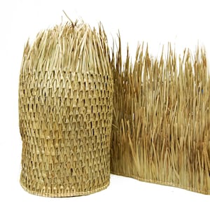 May include: A woven straw mat with a textured, woven pattern. The mat is made of natural, light brown straw and is ideal for adding a rustic touch to any space.