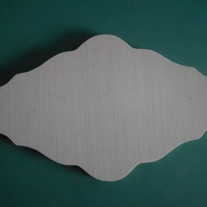 May include: A blank, white, wooden sign with a scalloped edge. The sign is shaped like a diamond and has a smooth, unfinished surface.