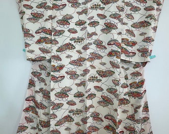 May include: A white kimono with a colorful pattern of circles and swirls. The pattern is reminiscent of a traditional Japanese design.