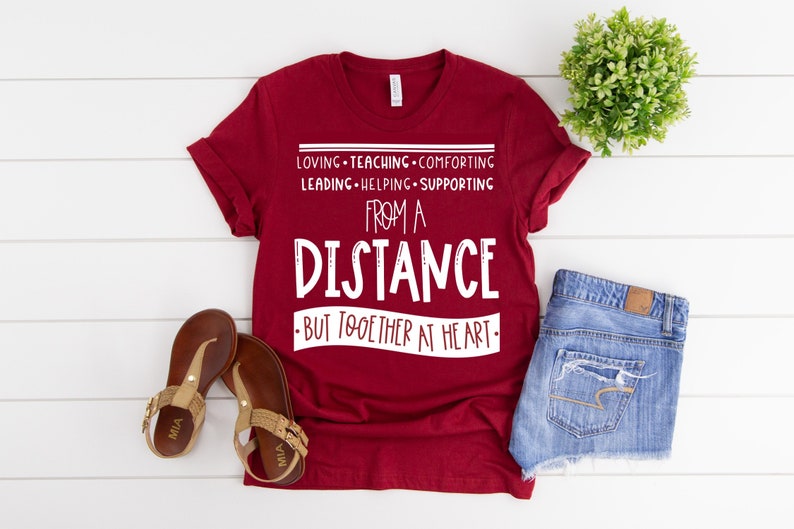 Może przedstawiać: Czerwona koszulka z białym tekstem, kt&oacute;ry brzmi "Loving - Teaching - Comforting - Leading - Helping - Supporting From A Distance - But Together At Heart - "