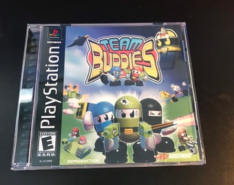 May include: A PlayStation game case for Team Buddies, a video game featuring colorful characters with guns. The case is blue and white with the game title in red and white. The ESRB rating is Everyone. The game is a reproduction.