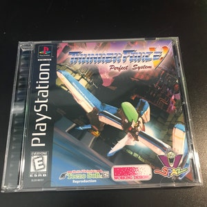 May include: A PlayStation video game case with a blue and green spaceship on the cover. The game is called "Thunder Force V: Perfect System" and is rated E for Everyone by the ESRB. The game is a reproduction of the original game by Tecno Soft.