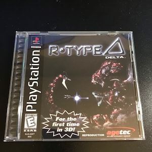 May include: A PlayStation game case for the game R-Type Delta. The case is black with a silver PlayStation logo and the game title in white. The game is rated E for Everyone by the ESRB. The case also features a red and white starburst with the text "For the first time in 3D!" and a red and white logo for Agetec.