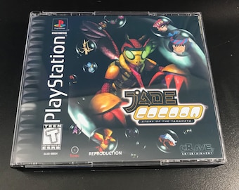May include: A PlayStation game case for Jade Cocoon: Story of the Tamamayu. The case is black with a colorful image of a bug-like creature with a red, green, and yellow body. The title "Jade Cocoon" is in yellow and the subtitle "Story of the Tamamayu" is in white.