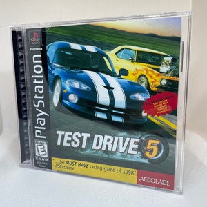 May include: A PlayStation game case for Test Drive 5, a racing game. The case is blue and yellow with a picture of two sports cars racing. The game is rated E for Everyone by the ESRB.