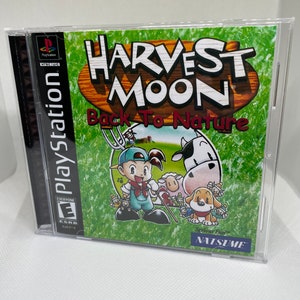Pode incluir: Caixa de jogo PlayStation para Harvest Moon: Back to Nature. A caixa é azul e branca com um fundo verde. O jogo apresenta um personagem de desenho animado com uma camisa vermelha e um chapéu azul. O jogo é classificado como E para todos.
