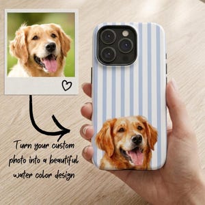 Puede incluir: Una funda para smartphone con un patrón de rayas verticales en azul claro y blanco, que presenta una ilustración estilo acuarela de un perro golden retriever en la parte inferior. La funda tiene un recorte negro para la cámara y acabado brillante.