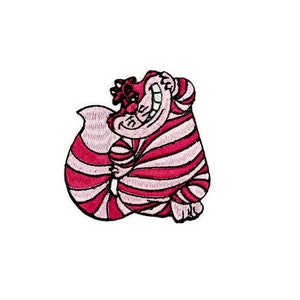 Op de afbeelding: Een roze en rood gestreepte Cheshire Cat uit Alice in Wonderland. De kat glimlacht met zijn mond open en heeft een ondeugende blik.