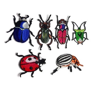 Może przedstawiać: Sześć haftowanych naszywek do prasowania przedstawiających różne rodzaje owadów. Naszywki obejmują niebieskiego chrząszcza, zielonego chrząszcza, czerwono-różowego chrząszcza, zielono-białego chrząszcza, czerwoną biedronkę i czarno-białego pasiasta chrząszcza.