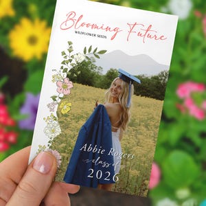 May include: A graduation announcement card with the text "Blooming Future" and "Wildflower Seeds." The card features a photo of a graduate in a field, with the name "Abbie Rogers" and "class of 2026."