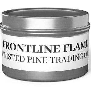 May include: A round, silver-colored metal tin with a lid. A white label is wrapped around the center, featuring the black text "FRONTLINE FLAME" on the top line and "TWISTED PINE TRADING CO." on the bottom line in a serif font.