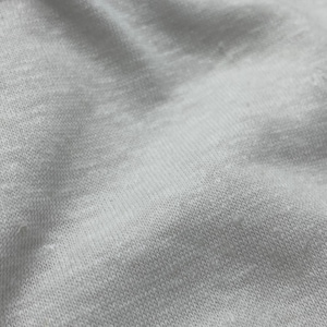 May include: Close-up of a white fabric with a textured surface. The fabric is soft and has a slightly wrinkled appearance.
