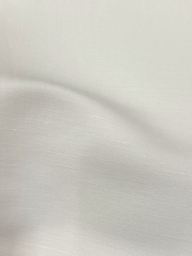 May include: A close-up of a white fabric with a subtle woven texture. The fabric has a smooth, soft appearance.