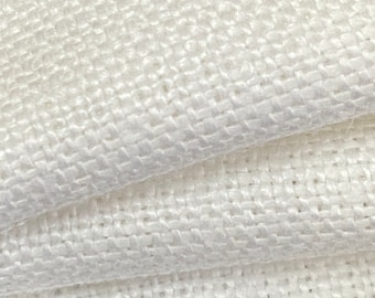 May include: White woven fabric with a textured, grid-like pattern. The fabric is folded in half, showing the texture from both sides.