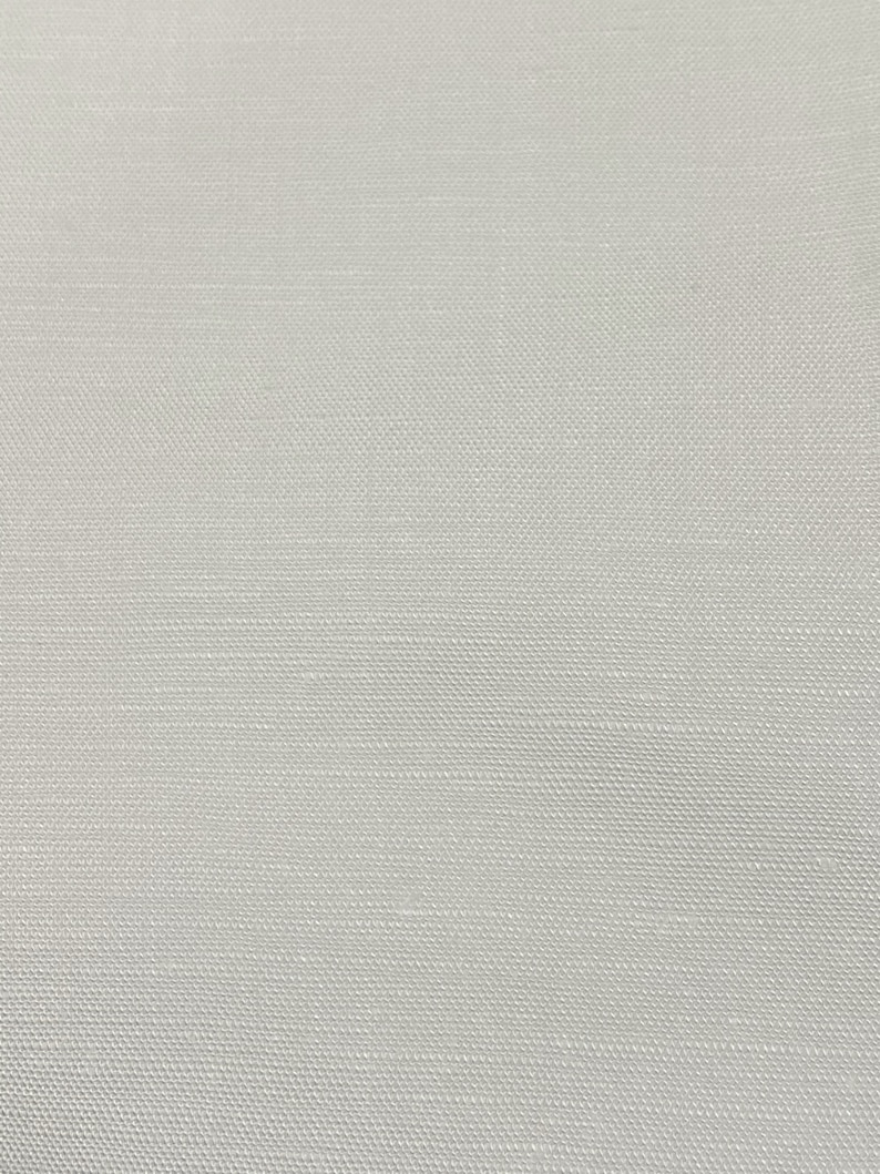 May include: A close-up of a white fabric with a subtle woven texture.