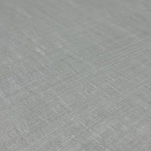 Puede incluir: Primer plano de una tela gris claro con un tejido sutil y texturizado. La superficie de la tela tiene una calidad ligeramente iridiscente, con l&iacute;neas diagonales y horizontales visibles. La apariencia general es suave y refinada.