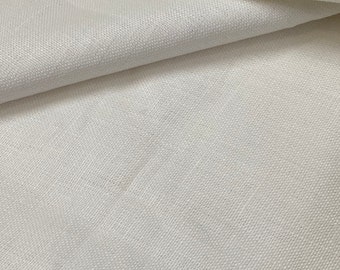 May include: Close-up of a white fabric with a subtle woven texture. The fabric is smooth and appears to be lightweight.