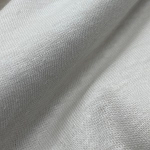May include: Close-up of a white, textured fabric with a soft, knit appearance.