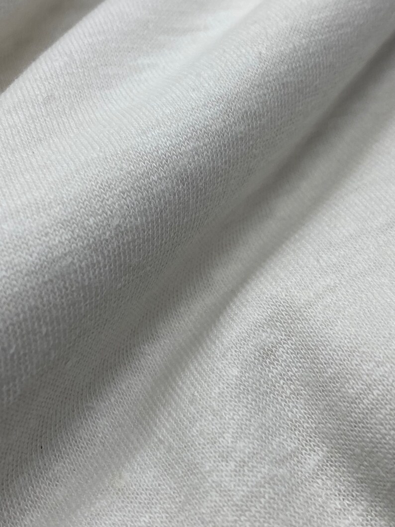 May include: Close-up of a white, textured fabric with a soft, knit appearance.