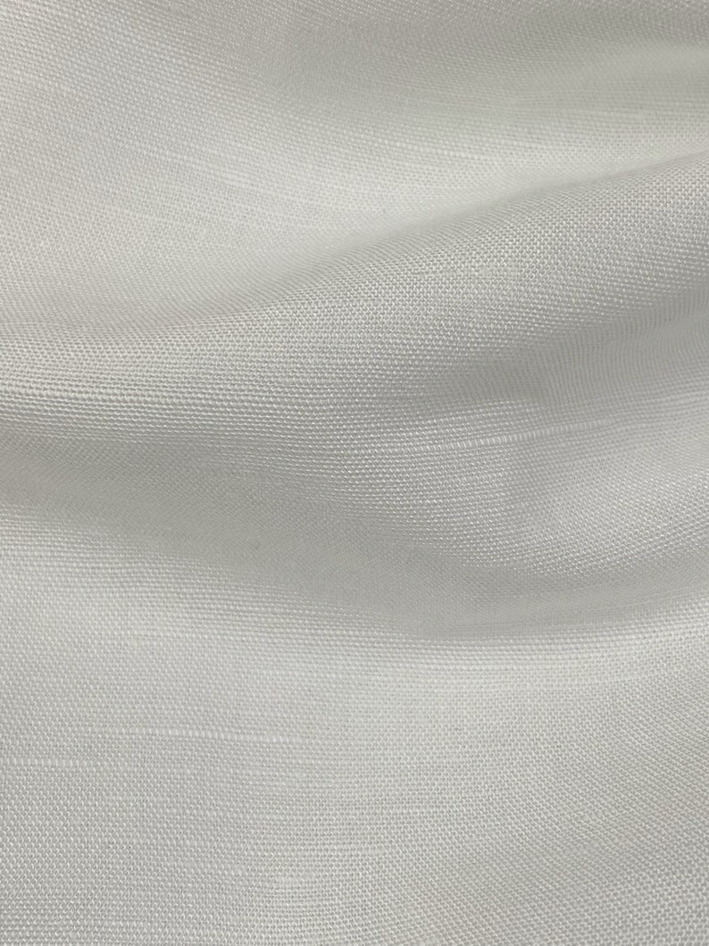 May include: White fabric with a subtle woven texture. The fabric is smooth and has a slight sheen.