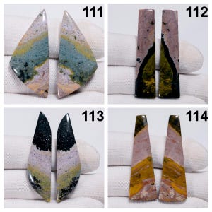 May include: Four pairs of polished gemstone cabochons. Each pair features unique patterns and colors, including shades of green, pink, yellow, and black. The cabochons are numbered 111, 112, 113, and 114. These are ideal for jewelry making or collecting.