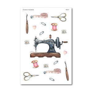 May include: A sheet of watercolour stickers featuring sewing-related items. The design includes a vintage sewing machine, scissors, measuring tape, spools of thread, safety pins, and seam rippers. The colour palette includes brown, pink, and gold, with the text "STUDIO TIKAMON".