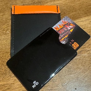 El tarjetero de cuero para tarjetas de regalo, tarjetas de crédito y tarjetas de identificación cuenta con una funda de bloqueo RFID que bloquea señales y escaneos.