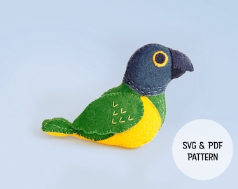 May include: A felt parrot toy with green, yellow, and blue felt. The parrot has a black eye and a yellow beak. The image includes the text "SVG & PDF PATTERN".
