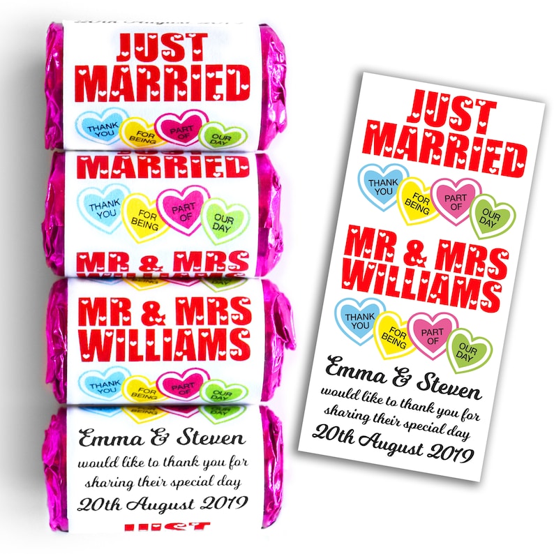 May include: Four candy bars wrapped in bright pink foil with white labels featuring red text that reads JUST MARRIED, MR & MRS WILLIAMS, and Emma & Steven would like to thank you for sharing their special day 20th August 2019 with heart graphics.