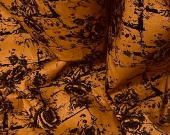 Tessuto in cotone 100% con stampa floreale arancione bruciato e nera, larghezza 45 pollici. PREZZO AL METRO.