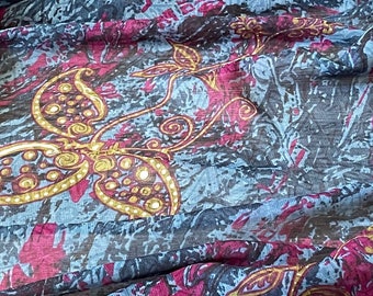 May include: A blue and burgundy fabric with a paisley pattern in gold. The fabric is sheer and has a soft, flowing texture.