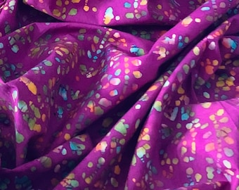 May include: Purple fabric with a colorful batik pattern. The fabric has a soft, flowing texture and is perfect for crafting or sewing projects.