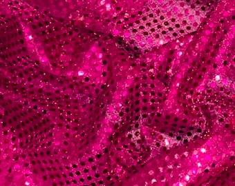May include: A close-up of a pink fabric with a sparkly, sequin texture. The sequins are small and evenly spaced, creating a shimmering effect.