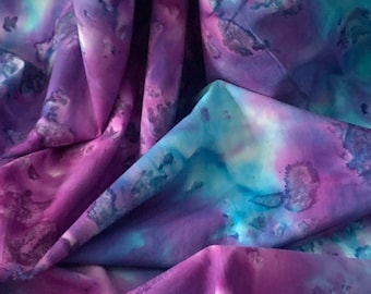 May include: Close-up of a purple and blue tie-dye fabric with a soft, flowing texture.