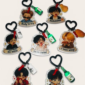 Può includere: Sette portachiavi in acrilico con personaggi dei cartoni animati e banner di testo. Ognuno ha un anello nero a forma di cuore, un piccolo ciondolo a forma di peperoncino rosso e un accessorio in miniatura come una bottiglia o pollo.