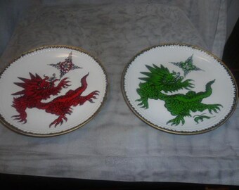 2 wall plates with red and green dragon pattern and gold rim by Kahla Made in GDR hand painted approx. 23.5 cm tall. Without damage