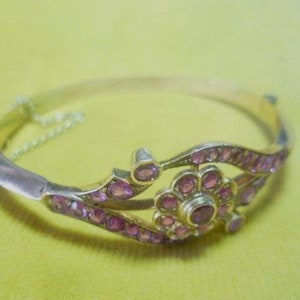 Gold bangle (375) set with rubies, approx. 1.7 ct, circa 1870, with push clasp and safety chain.