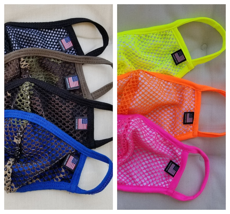 May include: Five different colored mesh face masks with elastic ear loops. The masks are made of a breathable material and feature a small American flag patch on the lower right corner. The colors are camouflage, black, blue, orange, and pink.
