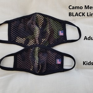 May include: Two camo mesh face masks with black lining. The larger mask is labeled "Adult" and the smaller mask is labeled "Kids".