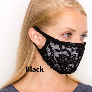 May include: A black lace face mask with a floral pattern. The mask is worn by a person with blonde hair.